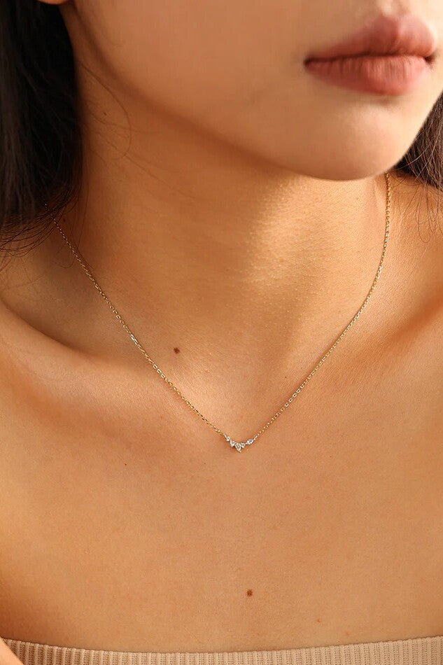 Woman wearing gold necklace with gemstone pendant