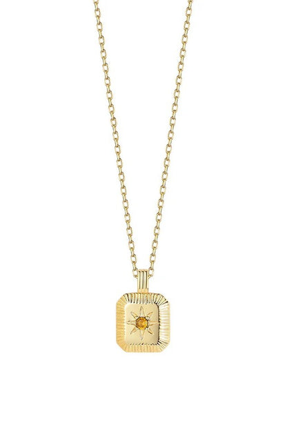 Gold necklace with a square pendant featuring an orange gemstone on a white background