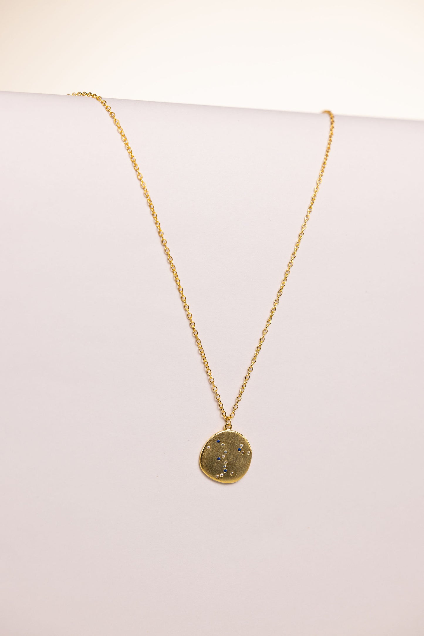 Gold necklace with a pendant on a white background