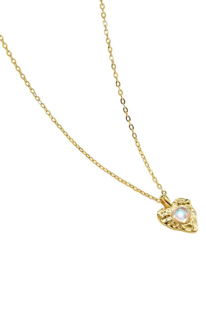 Gold necklace with a heart-shaped pendant featuring a moonstone on a white background